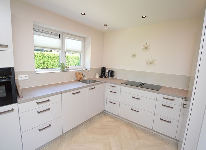 Modernes Wohnzimmer im Bungalow 't Hoogelandt 58, Texel, mit bequemen Sofas und stilvollen Moebeln.