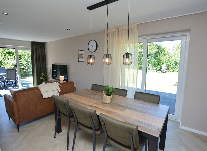 Modernes Wohnzimmer im Bungalow 't Hoogelandt 58, Texel, mit bequemen Sofas und stilvollen Moebeln.