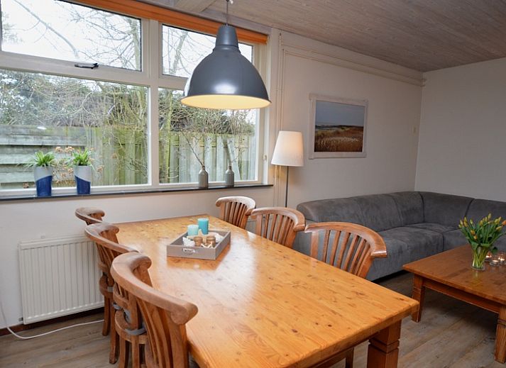 Gemuetliches Wohnzimmer des Ferienhauses Iris in De Dennen, Texel mit geraeumiger Sitzecke und Essbereich.