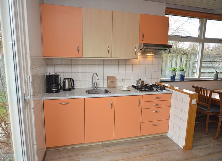 Gemuetliches Wohnzimmer des Ferienhauses Iris in De Dennen, Texel mit geraeumiger Sitzecke und Essbereich.