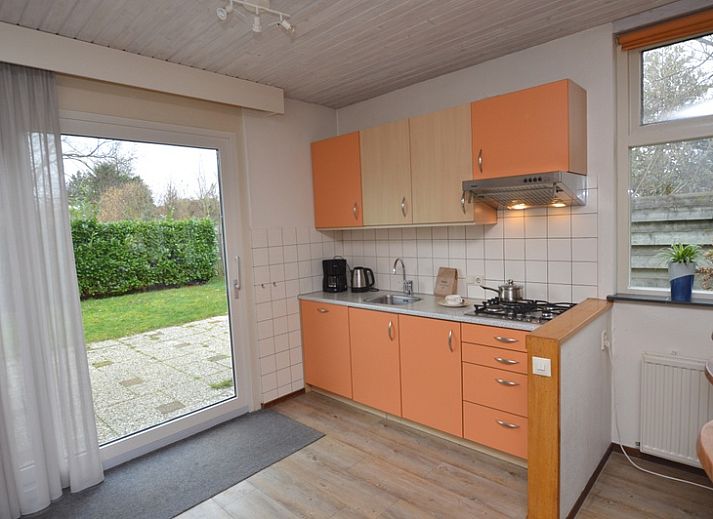 Gemuetliches Wohnzimmer des Ferienhauses Iris in De Dennen, Texel mit geraeumiger Sitzecke und Essbereich.