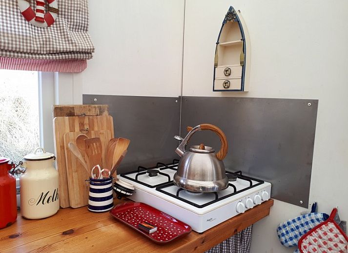 De Hagedis glamping lodge in Oost-Vlieland met terras en blauwe parasol tussen de duinen, Vlieland, Waddeneilanden.