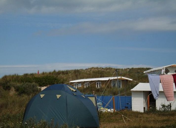 Binnenruimte van De Hagedis vakantiehuis met houten schuifdeur en zithoek, Oost-Vlieland, Vlieland, Waddeneilanden.