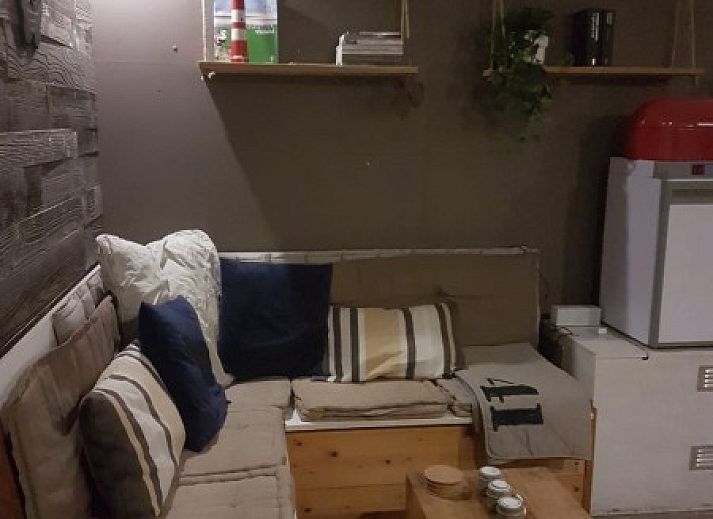 Binnenruimte van De Hagedis vakantiehuis met houten schuifdeur en zithoek, Oost-Vlieland, Vlieland, Waddeneilanden.