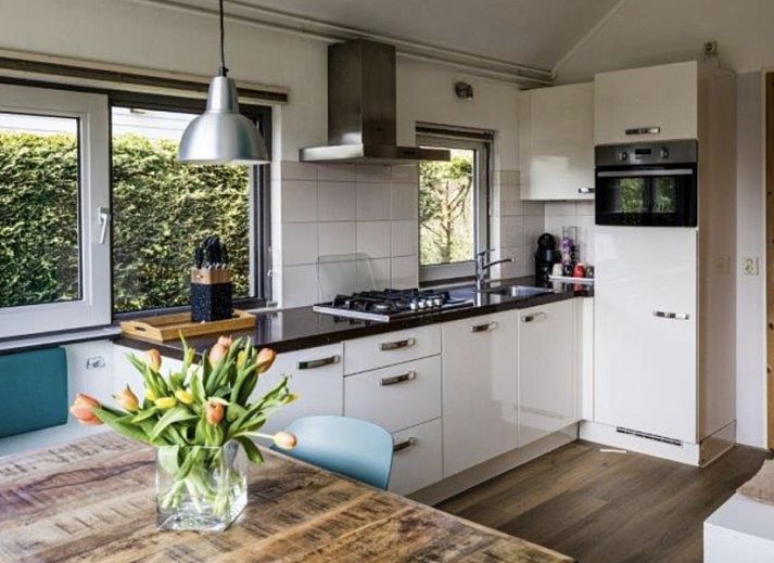 Cozy living room in vacation home Zeedistel, Formerum, Terschelling with bright interior and garden view.