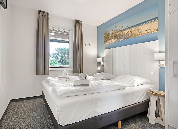 Gezellige woonkamer van het Vlieduyn 2-persoons appartement in Oost-Vlieland, met moderne meubels en flatscreen-tv.