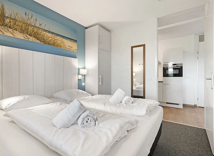 Gezellige woonkamer van het Vlieduyn 2-persoons appartement in Oost-Vlieland, met moderne meubels en flatscreen-tv.