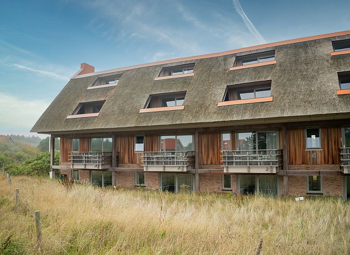 Eethoek in Vlieduyn 2-persoons appartement, Oost-Vlieland, met houten tafel en comfortabele stoelen.