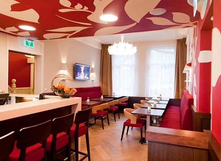 Buitenaanzicht van Hotel Van Walsum in Rotterdam, Zuid-Holland, met verlichte gevels en bomen in de avond.