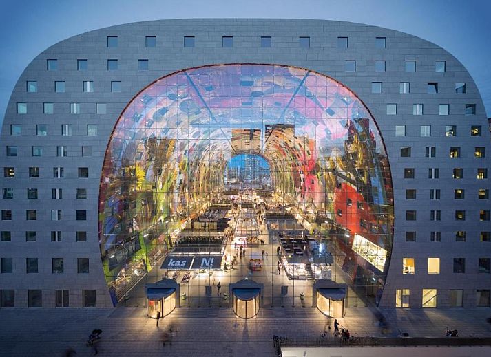 Buitenaanzicht van Hotel Van Walsum in Rotterdam, Zuid-Holland, met verlichte gevels en bomen in de avond.