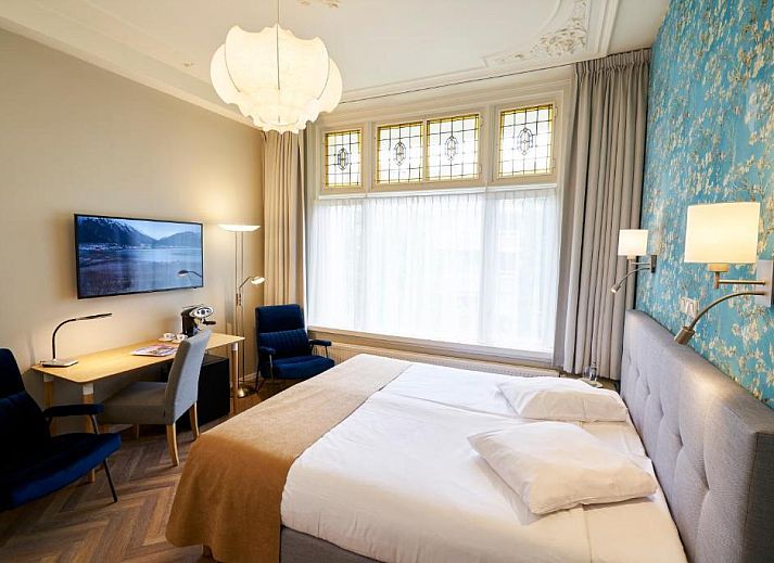 Comfortabele slaapkamer in Hotel Van Walsum, Rotterdam, met modern interieur en grote ramen.