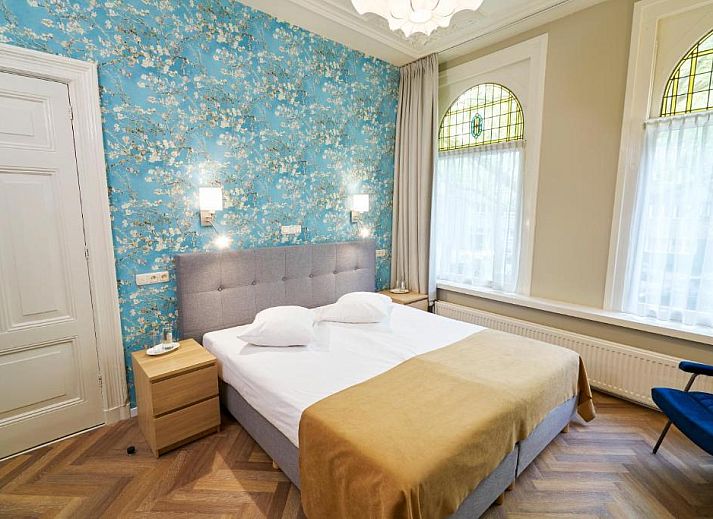 Comfortabele slaapkamer in Hotel Van Walsum, Rotterdam, met modern interieur en grote ramen.