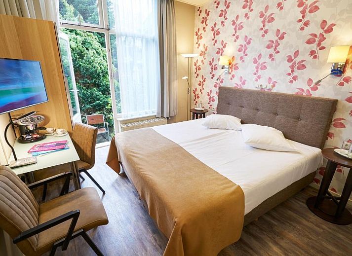 Comfortabele slaapkamer in Hotel Van Walsum, Rotterdam, met modern interieur en grote ramen.