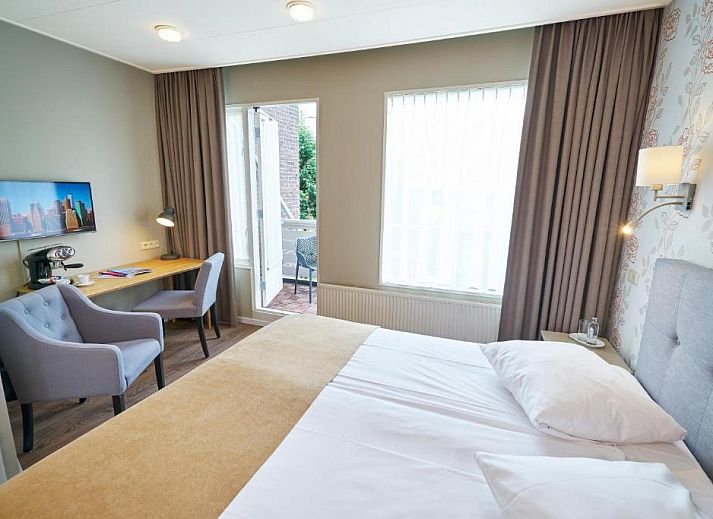 Comfortabele slaapkamer in Hotel Van Walsum, Rotterdam, met modern interieur en grote ramen.