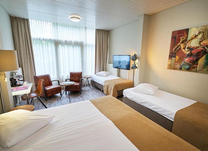 Elegant ingerichte slaapkamer in Hotel Van Walsum, Rotterdam, met uitzicht op de stad.