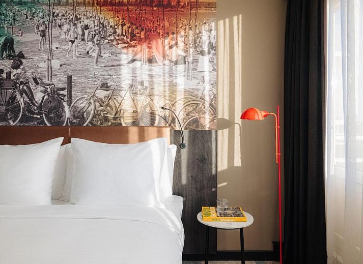 Gezellige slaapkamer in Savoy Hotel Rotterdam, vakantieappartement in Rotterdam, Zuid-Holland, met kleurrijke muurschildering.