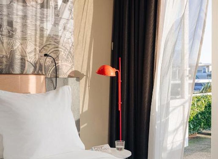 Chique eetruimte in Savoy Hotel Rotterdam, vakantieappartement in Rotterdam, Zuid-Holland, met kleurrijke stoelen en decor.