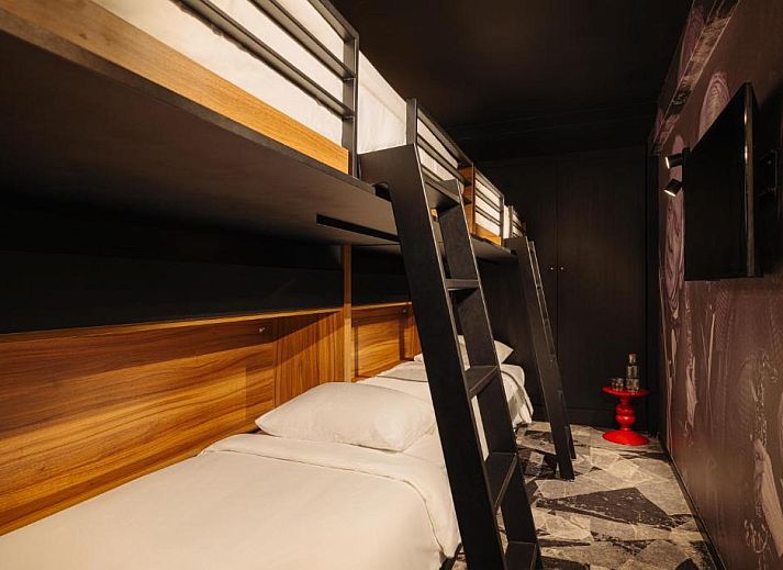 Chique eetruimte in Savoy Hotel Rotterdam, vakantieappartement in Rotterdam, Zuid-Holland, met kleurrijke stoelen en decor.