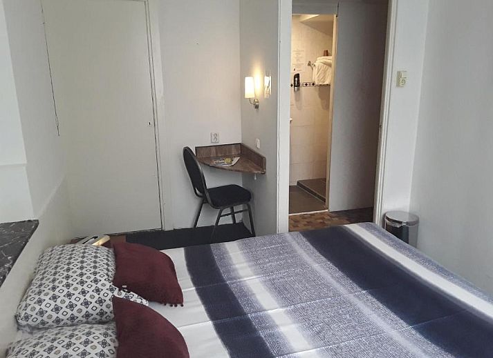 Hotel Baan in Rotterdam met groene gevel en vlaggen, ideaal vakantieappartement in Zuid-Holland.