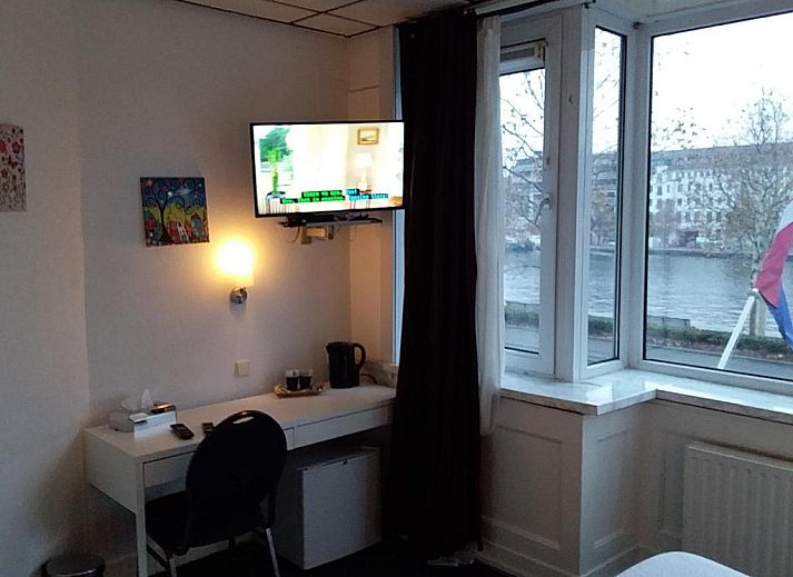 Hotel Baan in Rotterdam met groene gevel en vlaggen, ideaal vakantieappartement in Zuid-Holland.