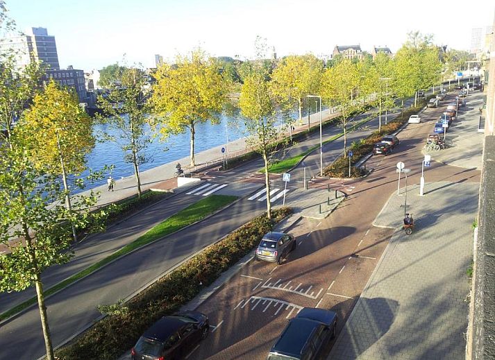 Hotel Baan in Rotterdam met groene gevel en vlaggen, ideaal vakantieappartement in Zuid-Holland.