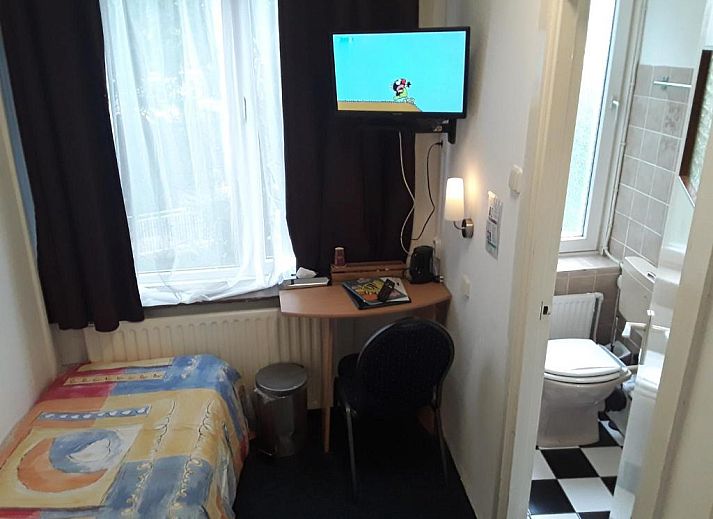 Comfortabele slaapkamer in Hotel Baan, Rotterdam, met bureau en badkamer voor een ontspannen verblijf.