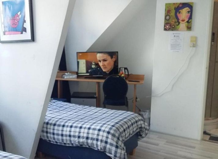 Stijlvolle kamer met bureau en tv in Hotel Baan, Rotterdam, geniet van het uitzicht op de omgeving.