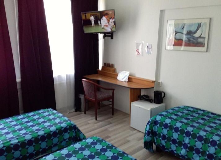 Stijlvolle kamer met bureau en tv in Hotel Baan, Rotterdam, geniet van het uitzicht op de omgeving.