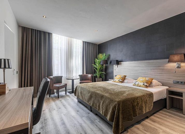 Comfortabele tweepersoonskamer in Hotel Milano, Rotterdam, vakantieappartement met stijlvolle inrichting en veel daglicht.