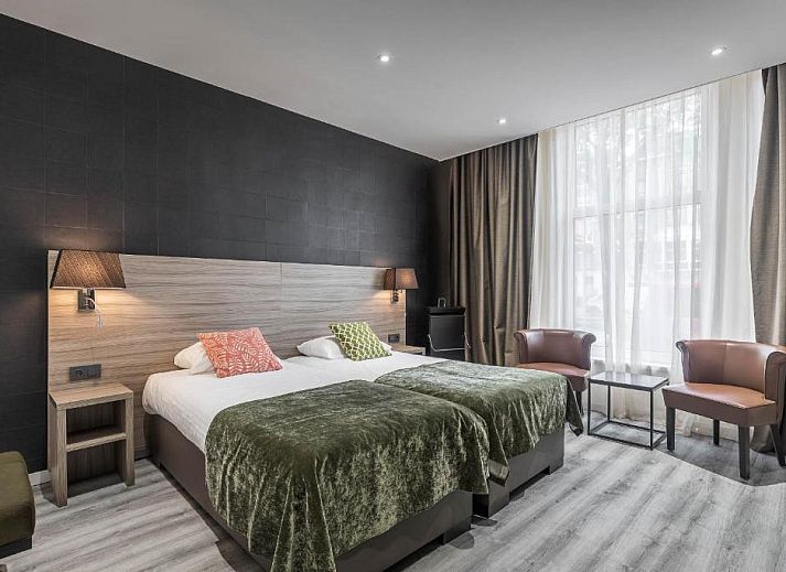 Praktische werkruimte in Hotel Milano, vakantieappartement in Rotterdam, met bureau, tv en opbergruimte.