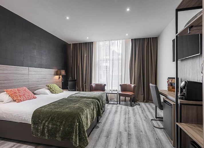 Praktische werkruimte in Hotel Milano, vakantieappartement in Rotterdam, met bureau, tv en opbergruimte.