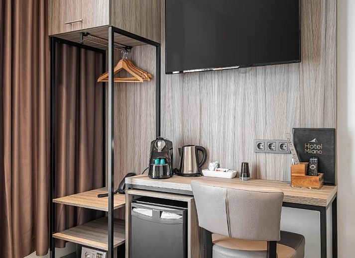 Eenvoudige eenpersoonskamer in Hotel Milano, vakantieappartement in Rotterdam, met knus bed en natuurlijk licht.