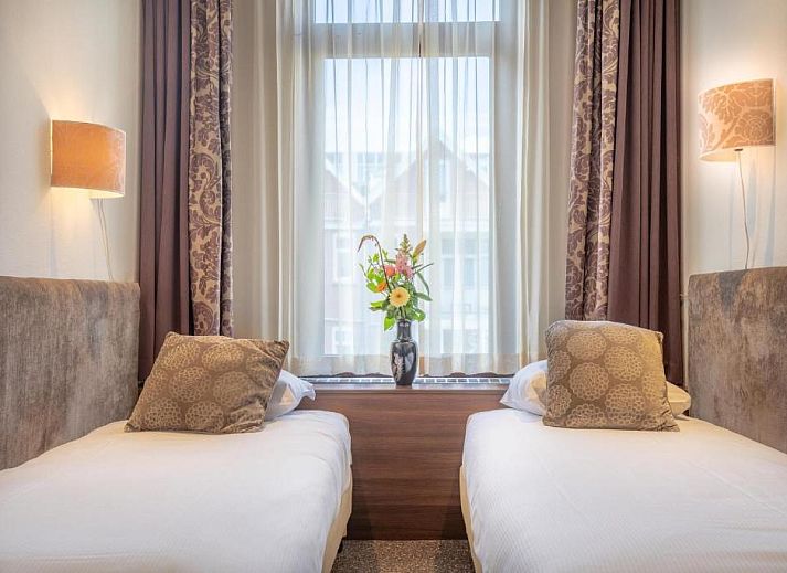 Eenvoudige eenpersoonskamer in Hotel Milano, vakantieappartement in Rotterdam, met knus bed en natuurlijk licht.