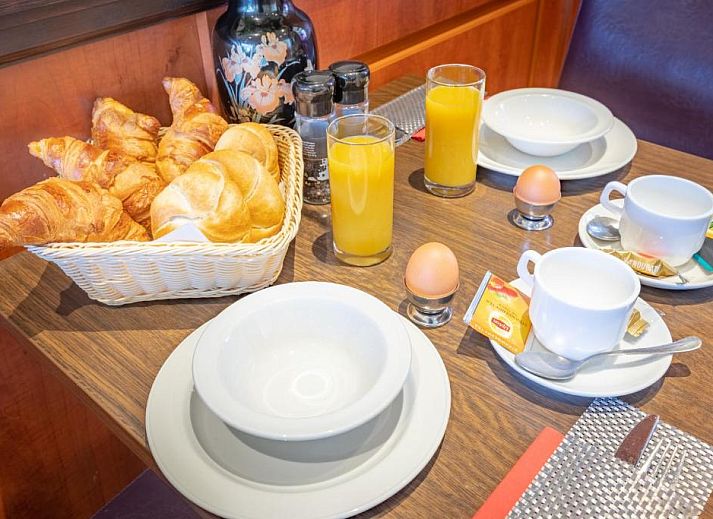 Eenvoudige eenpersoonskamer in Hotel Milano, vakantieappartement in Rotterdam, met knus bed en natuurlijk licht.