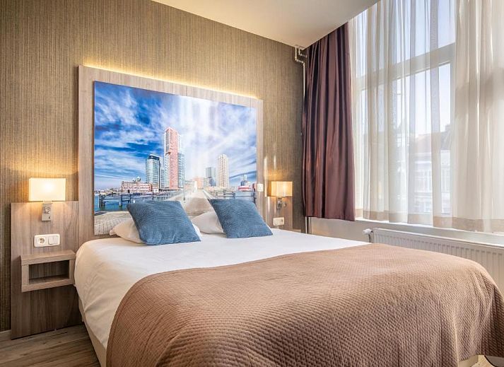 Eenvoudige eenpersoonskamer in Hotel Milano, vakantieappartement in Rotterdam, met knus bed en natuurlijk licht.