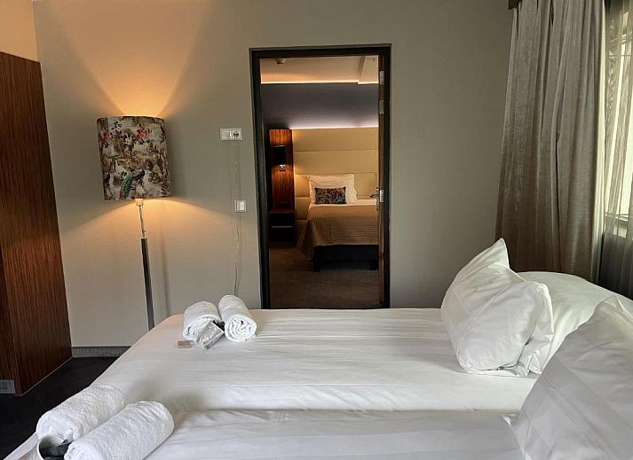 Luxe suite in Van der Valk Hotel Rotterdam - Blijdorp, elegant ingericht met een kingsize bed en zithoek.