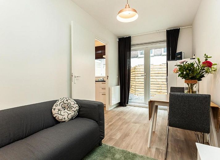 Cozy sitting area in Museumpark Apartments, Rotterdam, with open kitchen and dining table.