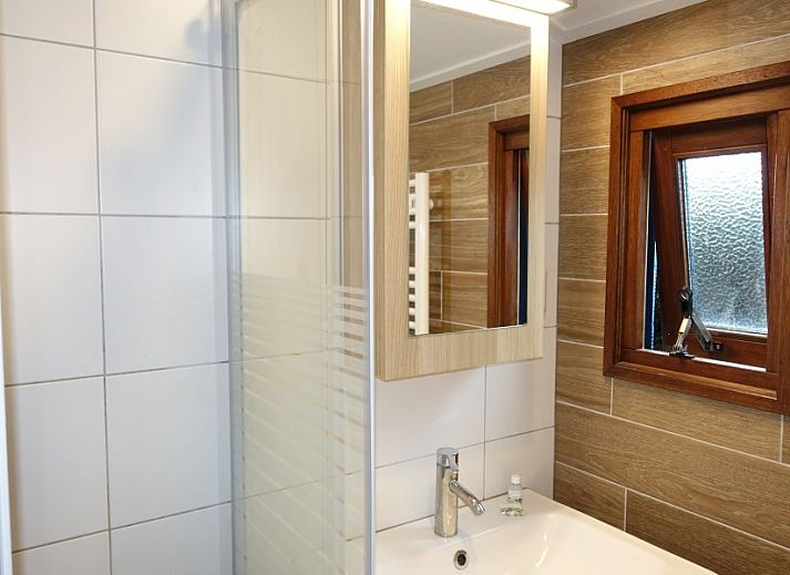 Comfortable sitting area in Noorderlicht vacation home, Formerum, Terschelling with bookshelf.