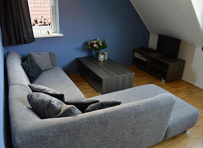 Gezellige eetruimte in Wijnberg Appartementen, Hollum, Ameland met keuken en tafel.