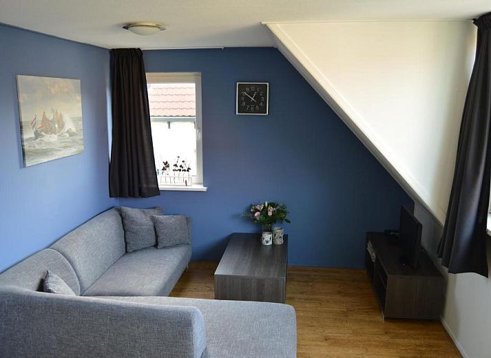 Gezellige eetruimte in Wijnberg Appartementen, Hollum, Ameland met keuken en tafel.