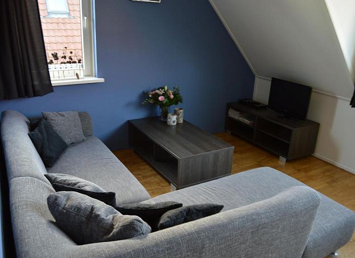 Gezellige eetruimte in Wijnberg Appartementen, Hollum, Ameland met keuken en tafel.