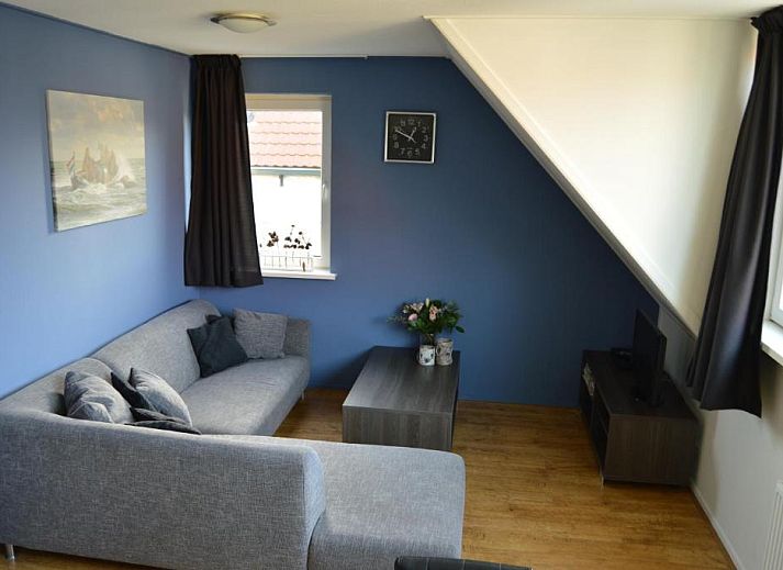 Stijlvolle woonkamer in Wijnberg Appartementen, Hollum, Ameland met grijze bank.