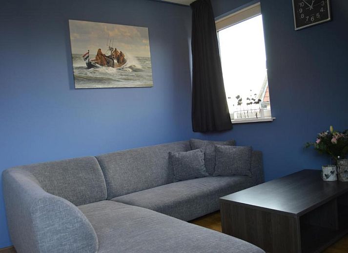 Stijlvolle woonkamer in Wijnberg Appartementen, Hollum, Ameland met grijze bank.