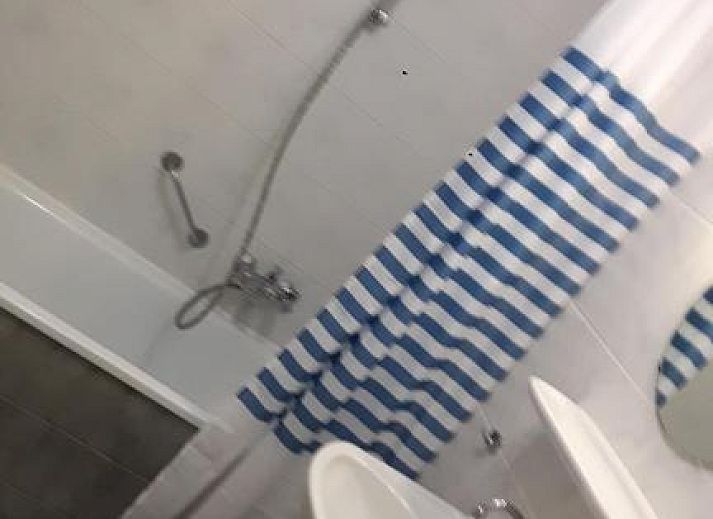 Terras van Appartement HELIOS - Amelander Kaap met ZWEMBAD in Hollum, Ameland, met kleurrijke stoelen en uitzicht op groen.