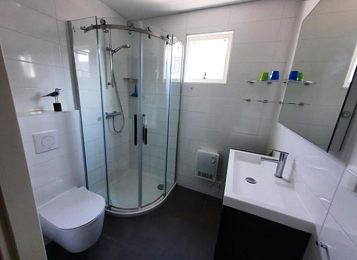 Kaapshoff 32 in Hollum, Ameland, Ferienwohnung mit gruener Umgebung und Flaggen.