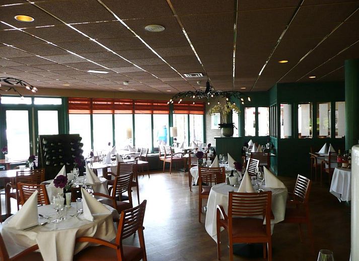 Kaapshoff 32 in Hollum, Ameland, Ferienwohnung mit gruener Umgebung und Flaggen.