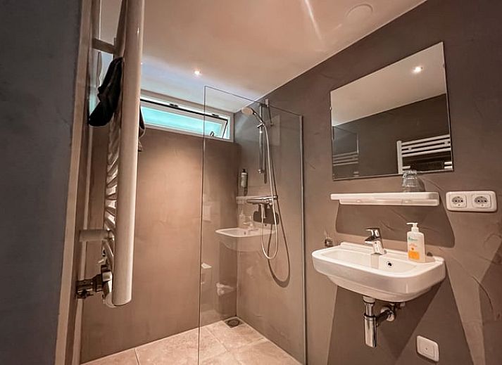 Buitenzijde van Huisje in Hoorn Terschelling, vakantiehuis omringd door dennenbomen op de Waddeneilanden.