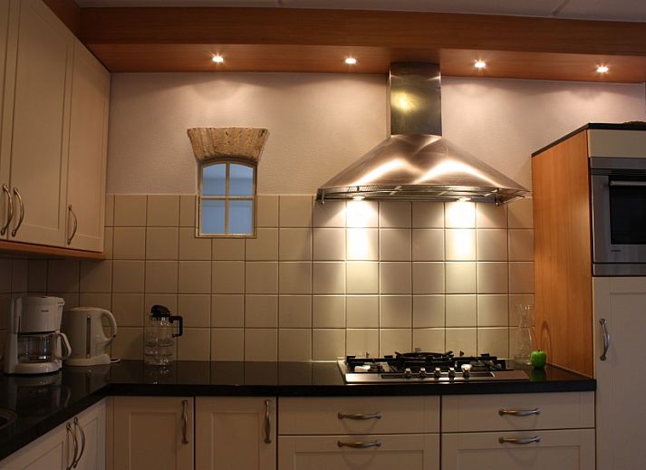 Eetkamer in Appartementenboerderij de Hek Oost, Hoorn, Terschelling met houten tafel en stoelen.