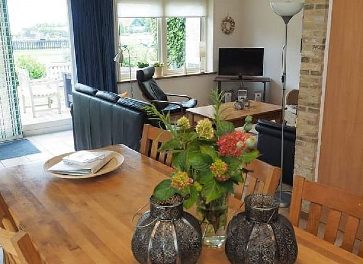 Eetkamer in Appartementenboerderij de Hek Oost, Hoorn, Terschelling met houten tafel en stoelen.