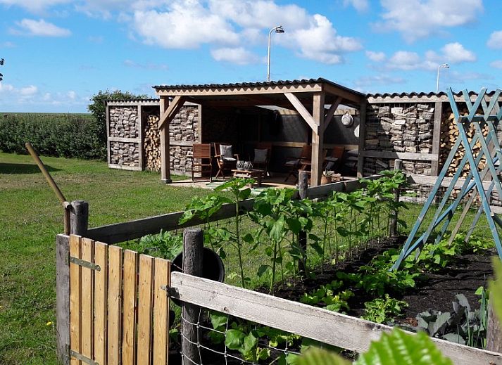 Eetkamer in Appartementenboerderij de Hek Oost, Hoorn, Terschelling met houten tafel en stoelen.